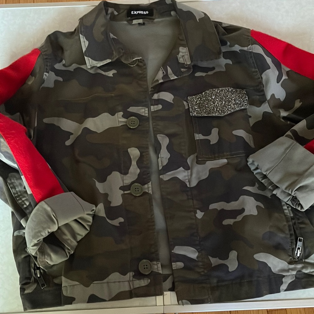 Camouflage jacket with elastic waist and red stripe on sleeves.
